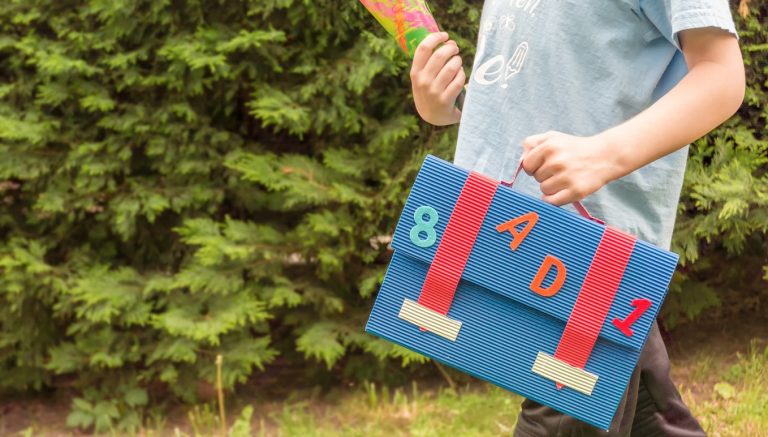 Child Carries Sugar Bag And Satchel To A Schooling Party