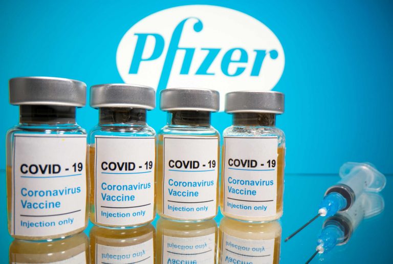 FILE PHOTO: Vials And Medical Syringe Are Seen In Front Of Pfizer Logo In This Illustration